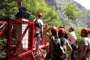 Participants of the activity promoting inter-community dialogue and inter-municipal co-operation line-up to ride the Zip Line, Rugova valley, 24 June 2019  (OSCE/Riccardo Celeghini)